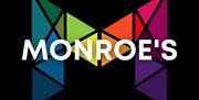 A large, geometric letter "M" made up of colorful, triangular shapes on a black background, with the word "MONROE'S" in bold white letters overlaid ac