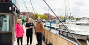 Guided tour on board the Spurn Lightship. 2 people are listening to information on the deck.